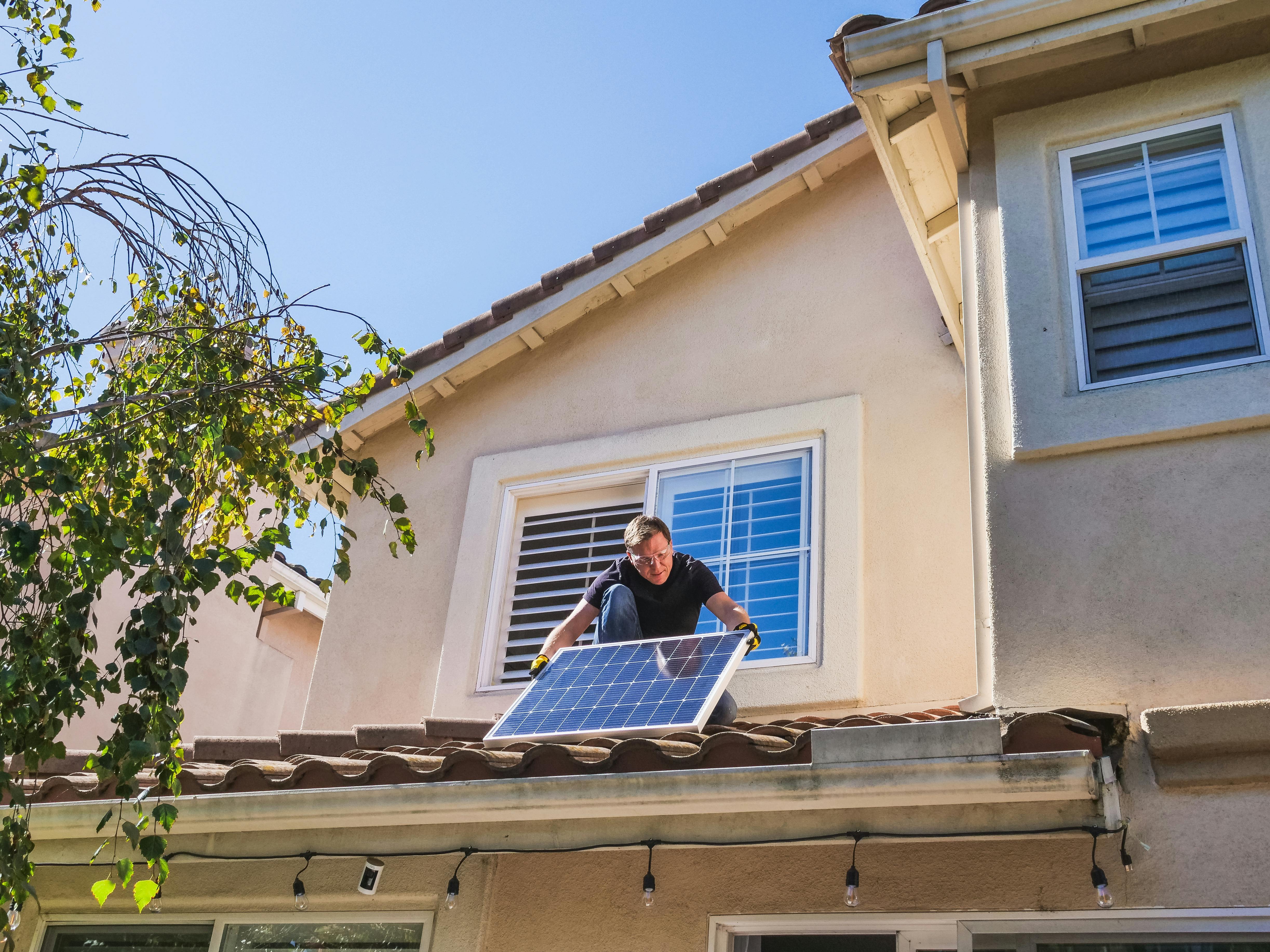 Person installing solar panels on the roof
